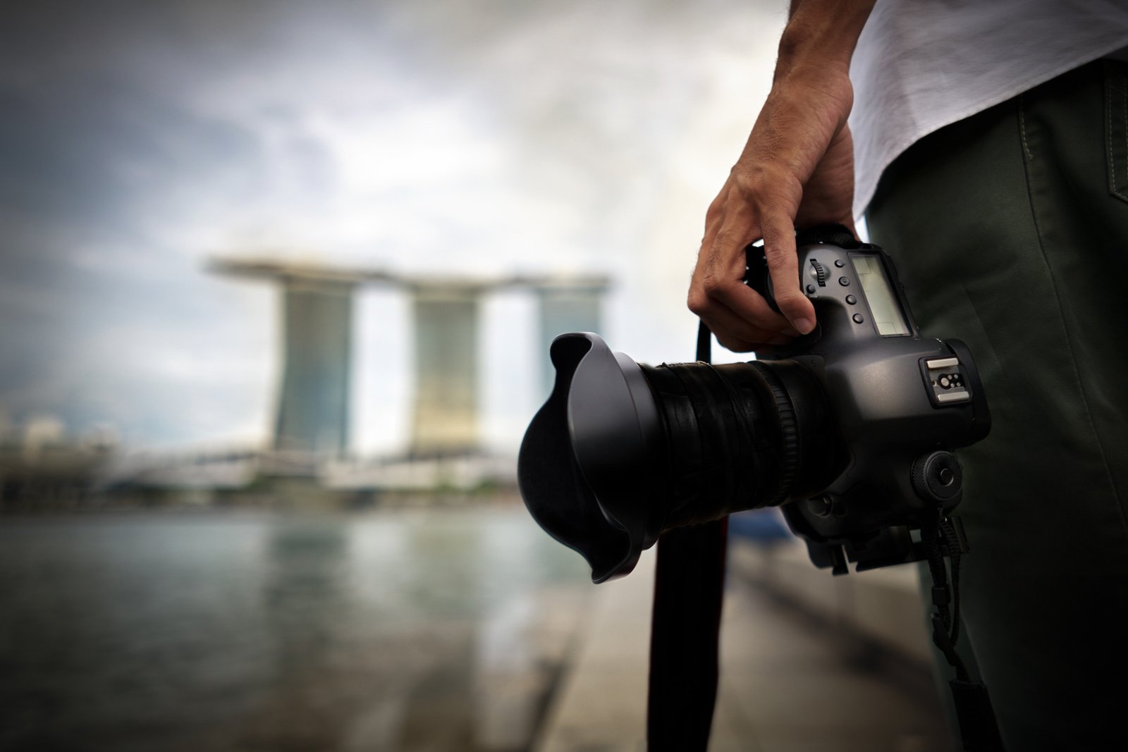 Close-up of a camera against the Singapore skyline